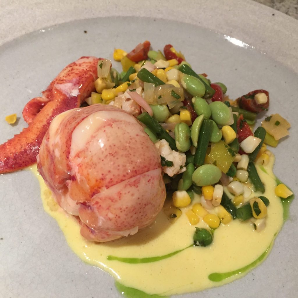 Butter poached Lobster, Nantucket summer Succotash with a sweet corn emulsion and chive blossom oil